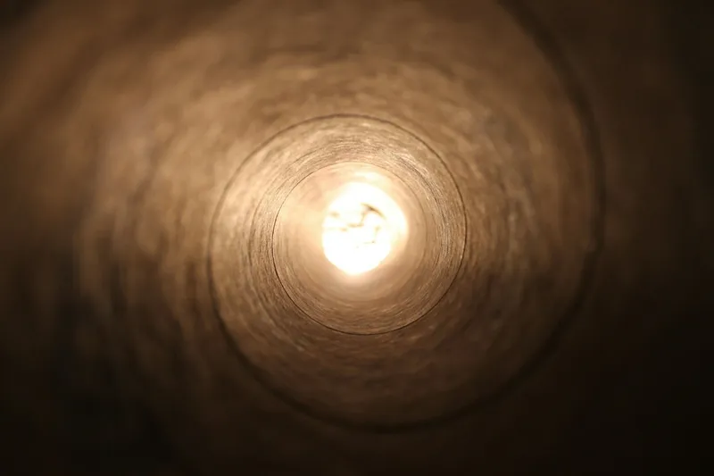 The inside of a long pipe, with light shining in from the far end.