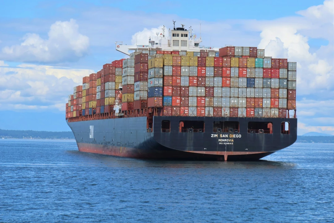 An enormous container ship filled to the brim with thousands of containers.