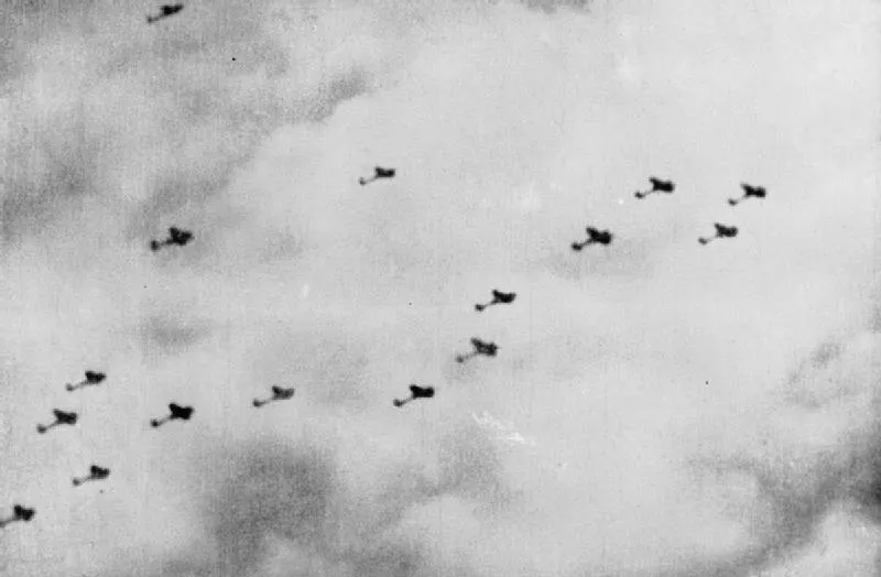 Black and white aerial photograph showing a squadron of military aircraft flying in formation through cloudy skies