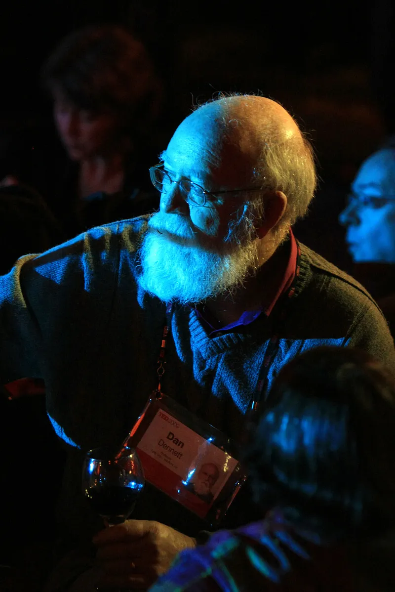 Elderly man with white beard and glasses sitting at TED conference